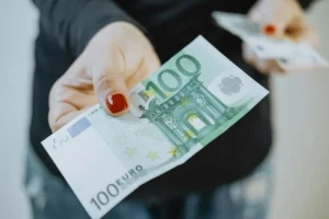 rohrreinigung preisliste Frau hält 100€ in der Hand