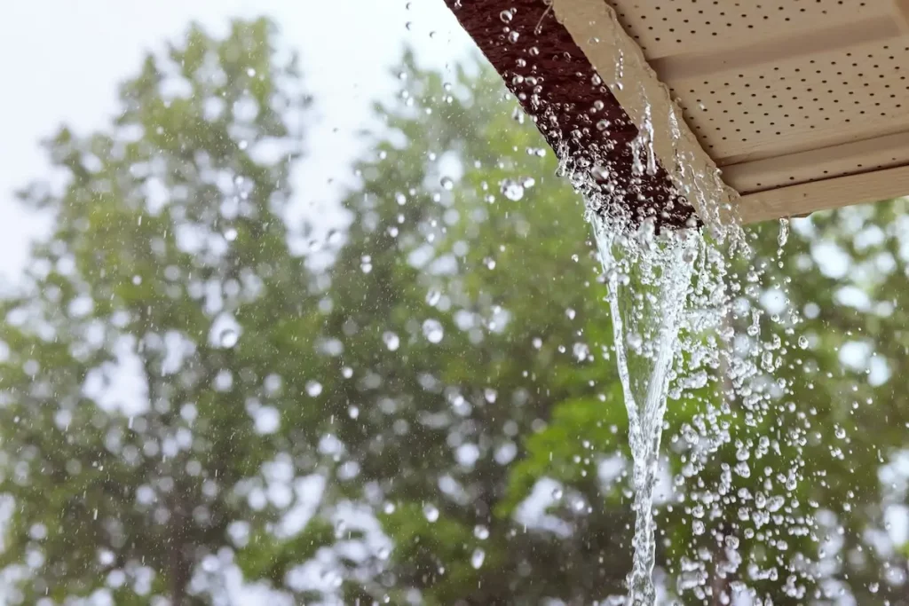 Dachrinne läuft über mit Wasser, weil sie verstopft ist